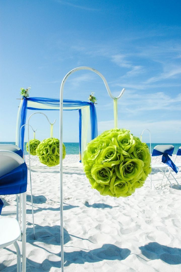 Beach wedding decorations with green floral balls and blue accents.