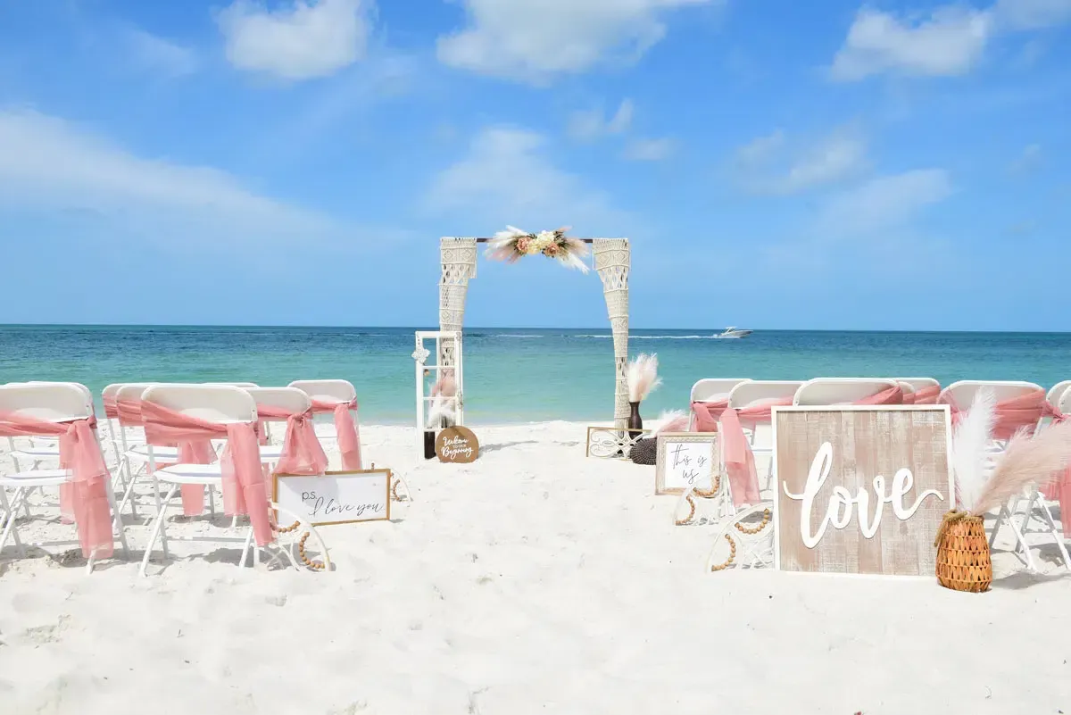 Beach wedding setup with arch, chairs, and 