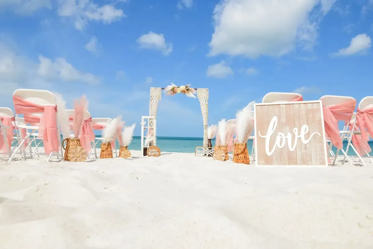 Beach wedding setup with chairs, arch, 