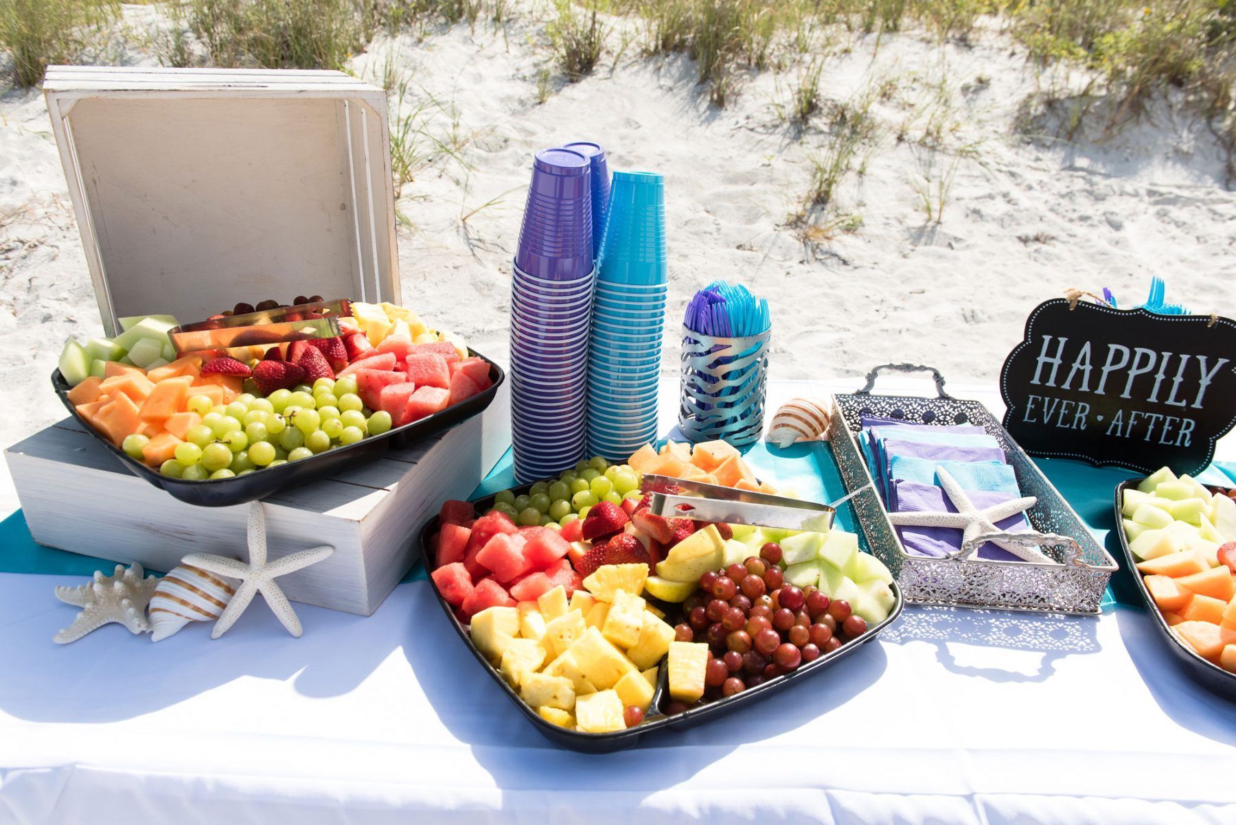 Beachside fruit platter with cups and