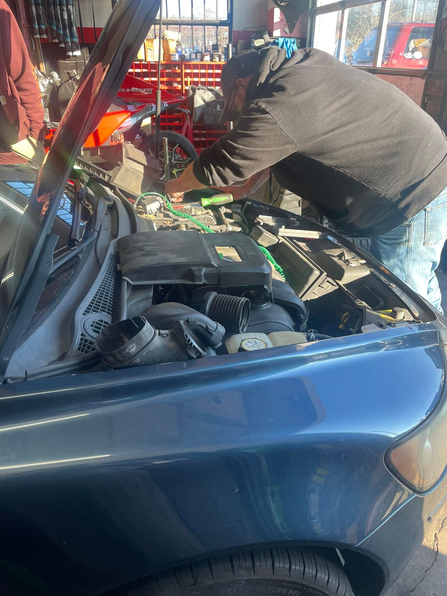 A white truck with the hood up is being worked on