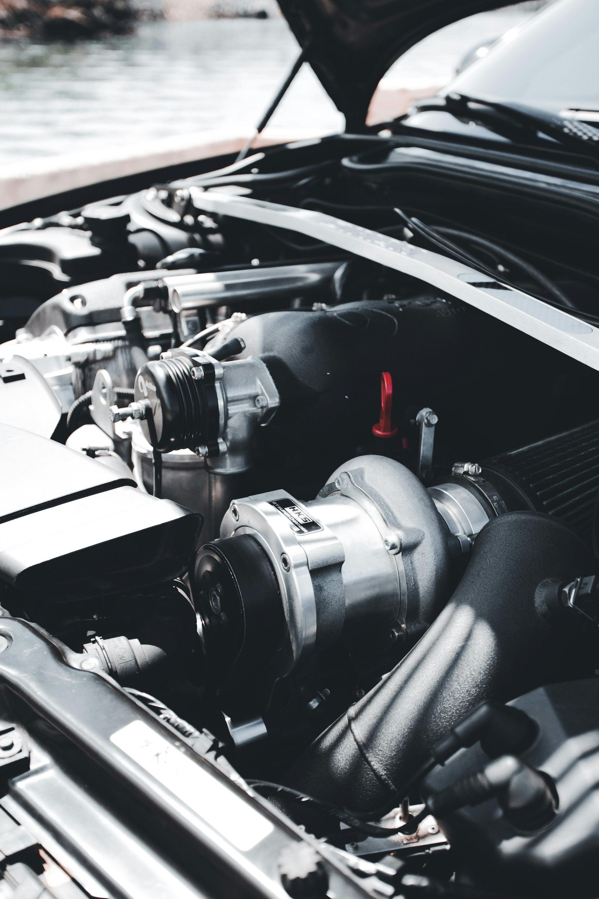 A man is holding a turbocharger on a table.