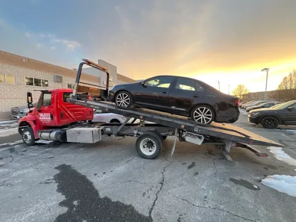 A car is being towed by a tow truck.