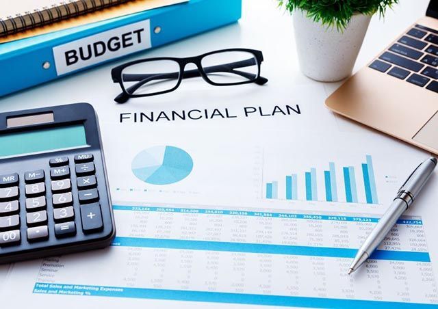paper-with-financial-plan-written-on+it-with+graphs-and-charts-a-calculator-pen-glasses-and-laptop