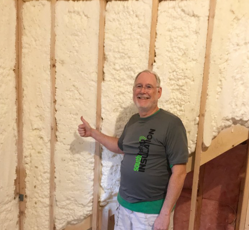 Happy homeowner in front of his walls of his house after a recent spray foam insulation job