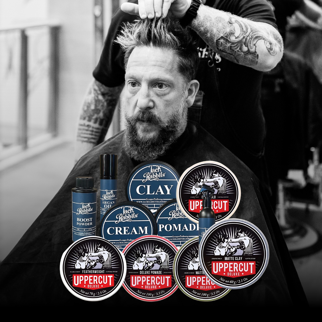 A man with a beard is getting his hair cut by a barber.