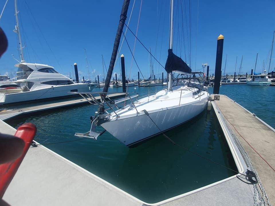 A White Sailboat is Docked at a Marina on a Sunny Day — Jacko's Auto & Marine Electrics In Mackay Harbour, QLD