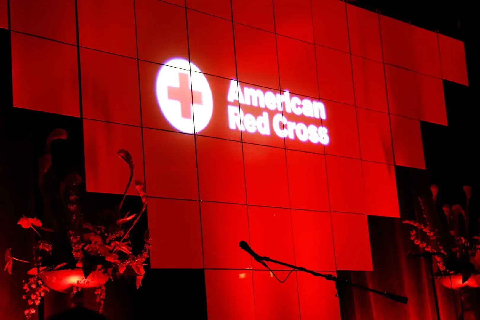 An american red cross sign is lit up in the dark
