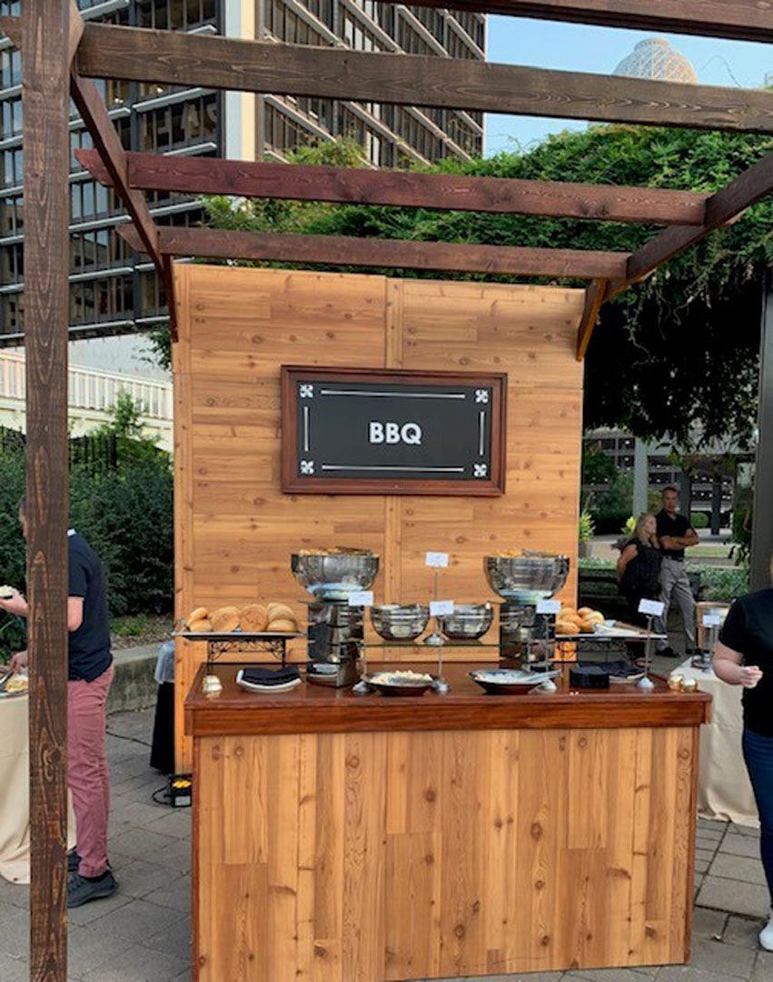 A wooden buffet table with a sign that says bbq on it.