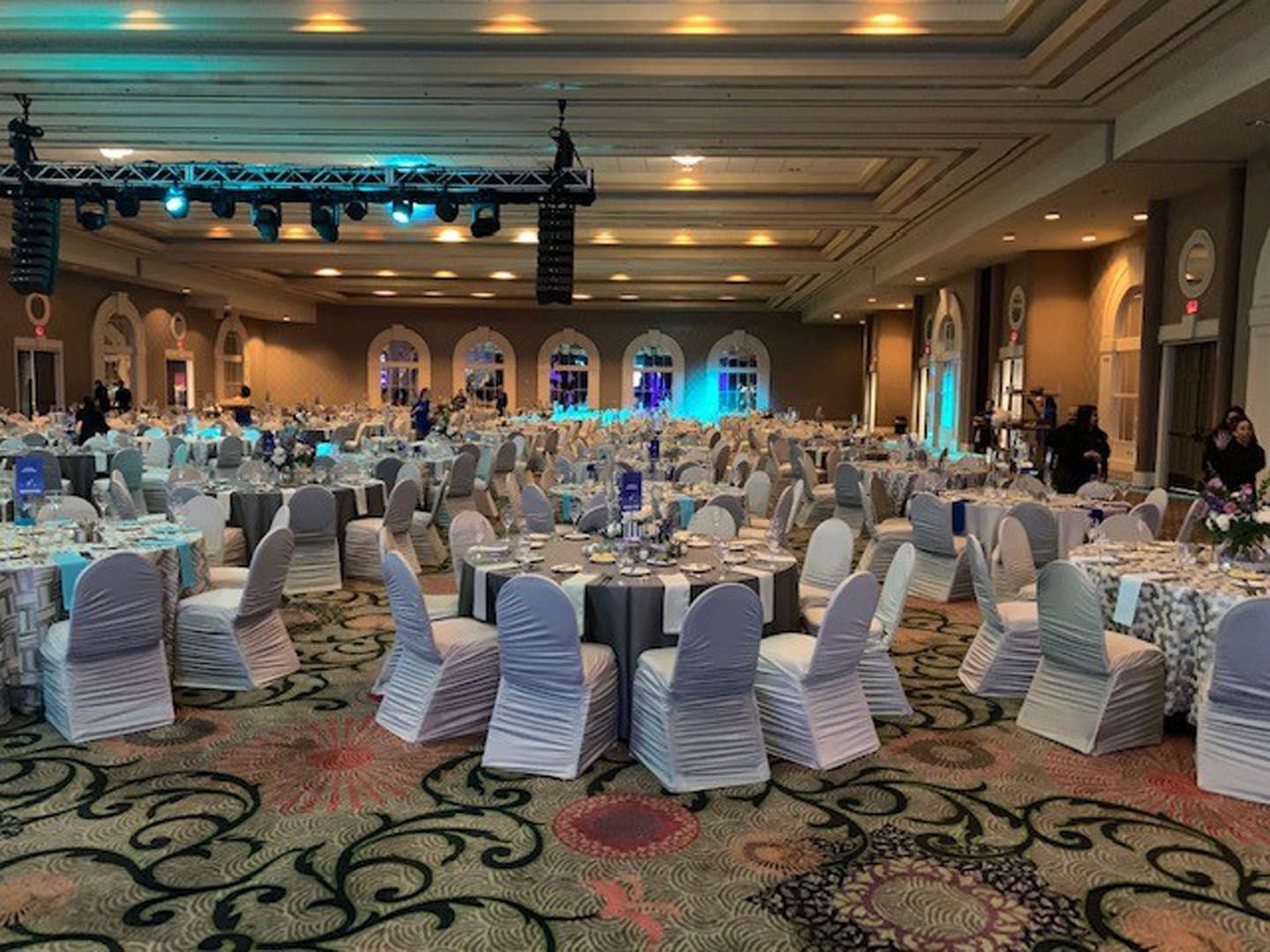 A large ballroom with tables and chairs set up for a wedding reception.