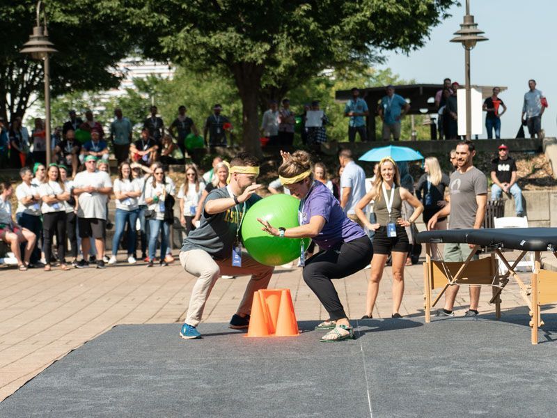 A group of people are playing a game with a green ball