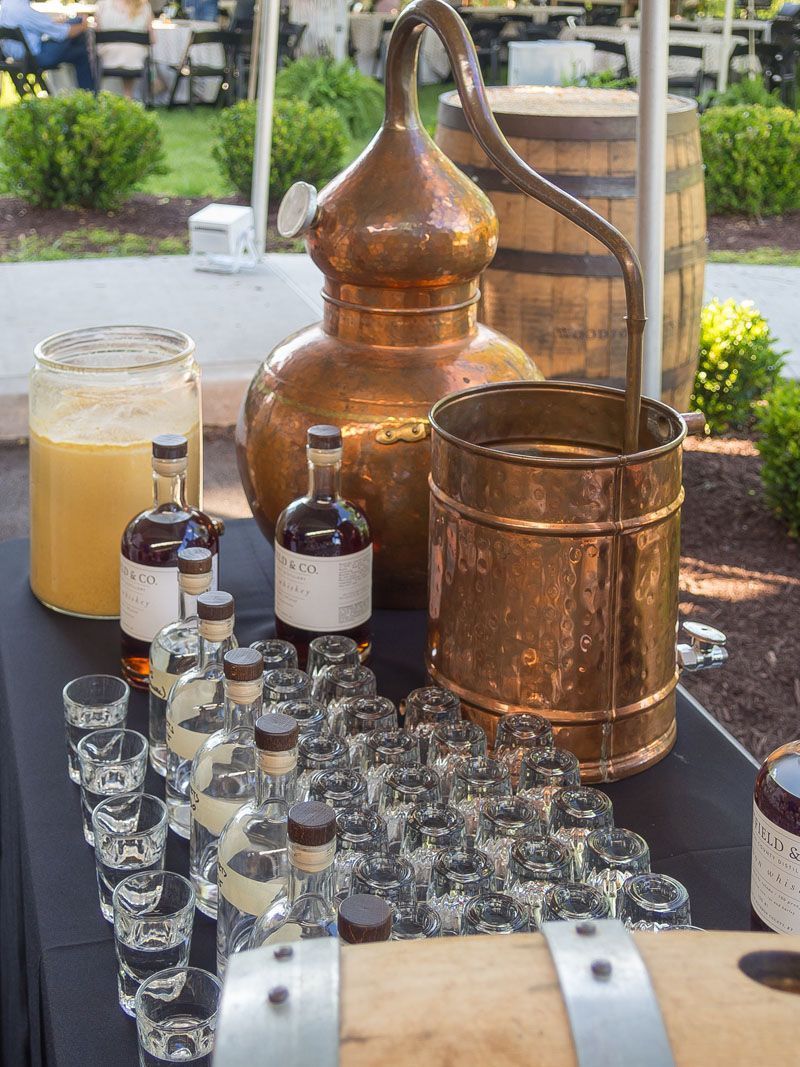 A table with bottles of liquor and shot glasses on it