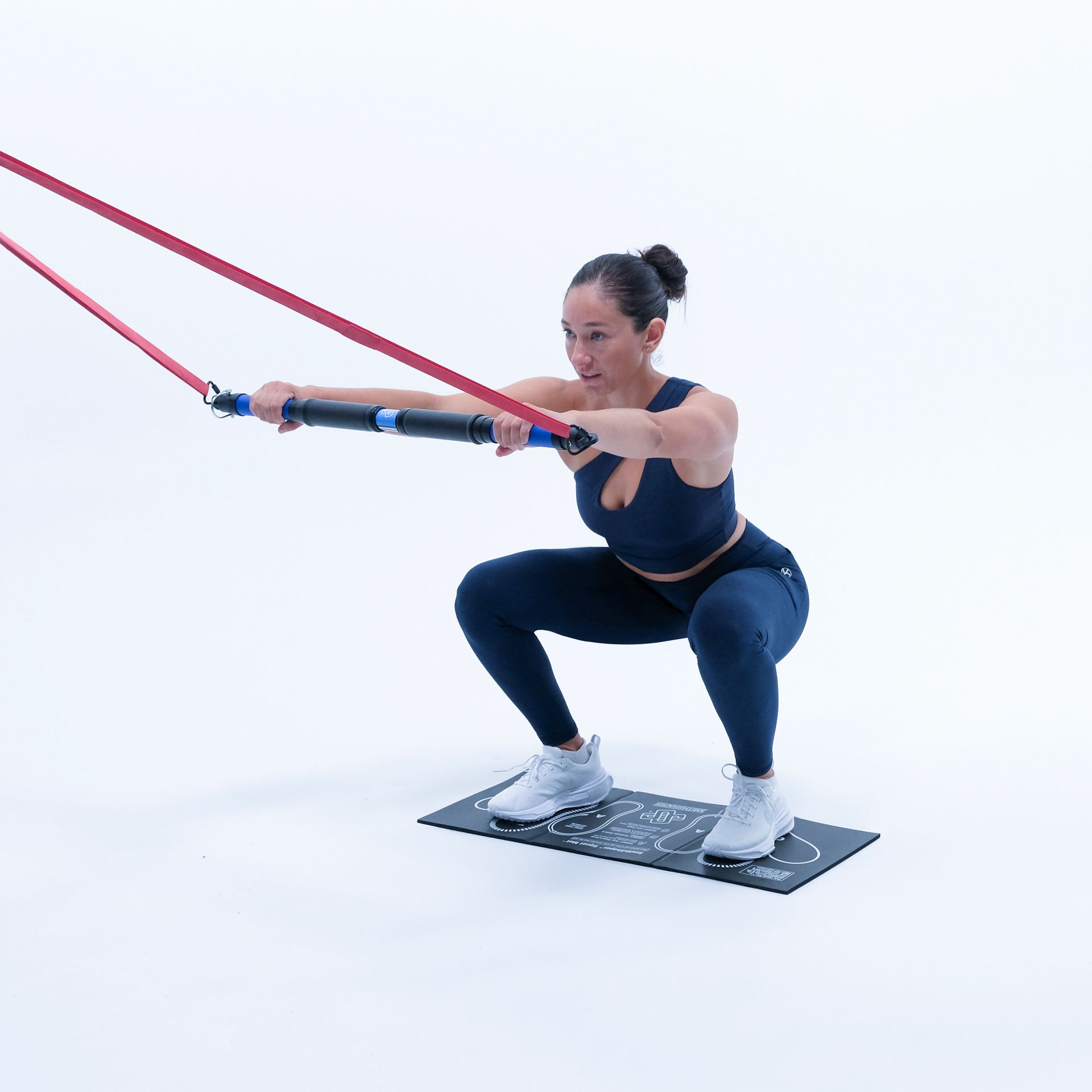 a woman is laying on the floor doing SmithShaper resistance band pedals exercise using a TR-BAR resistance  exerciser connected to a red SmithShaper 42-inch Zobo Sports High Stretch Therapy Resistance Loop Band