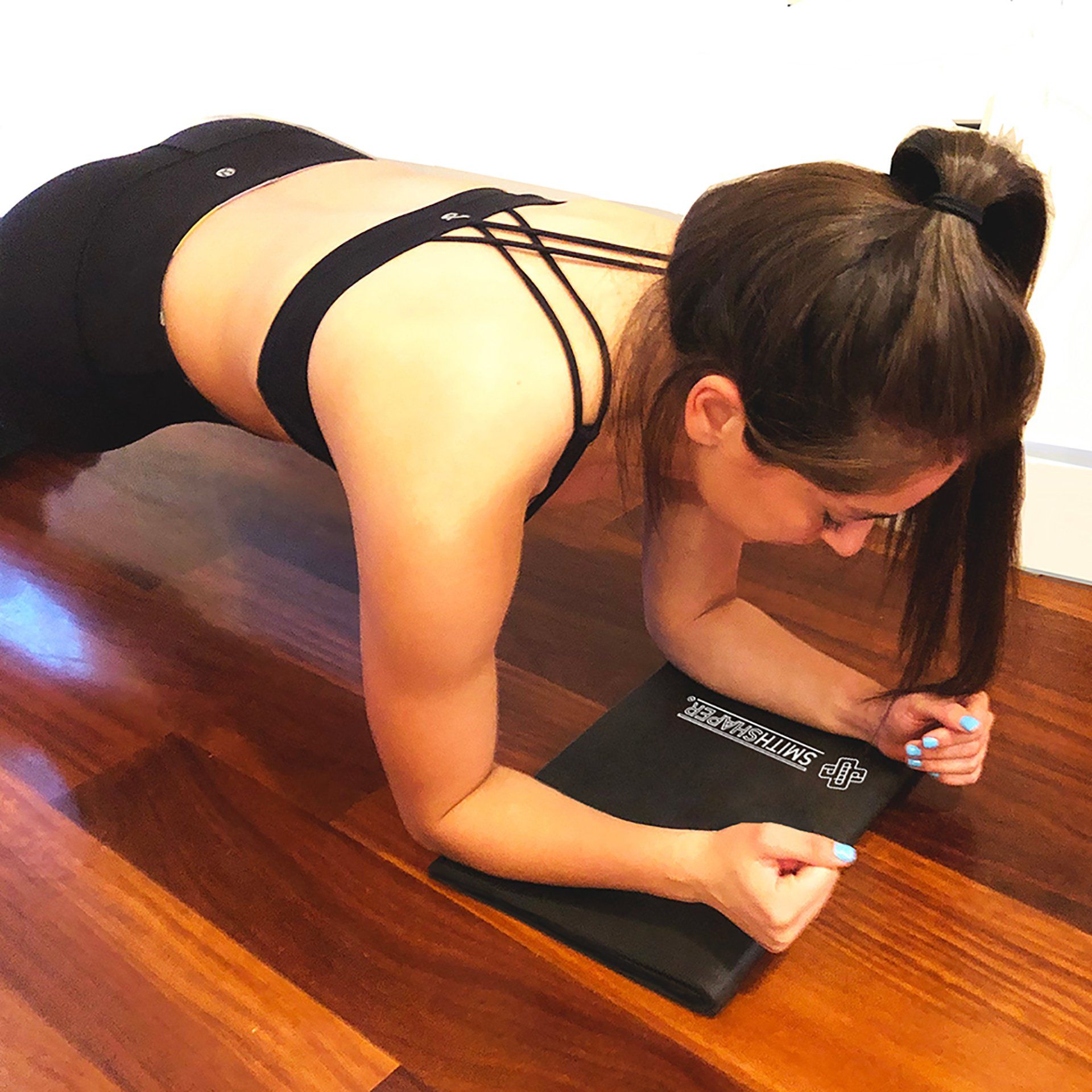 shows a woman performing SmithShaper rolling planks while cushioning her Forearms and Elbows with a SmithShaper Squat Mat
