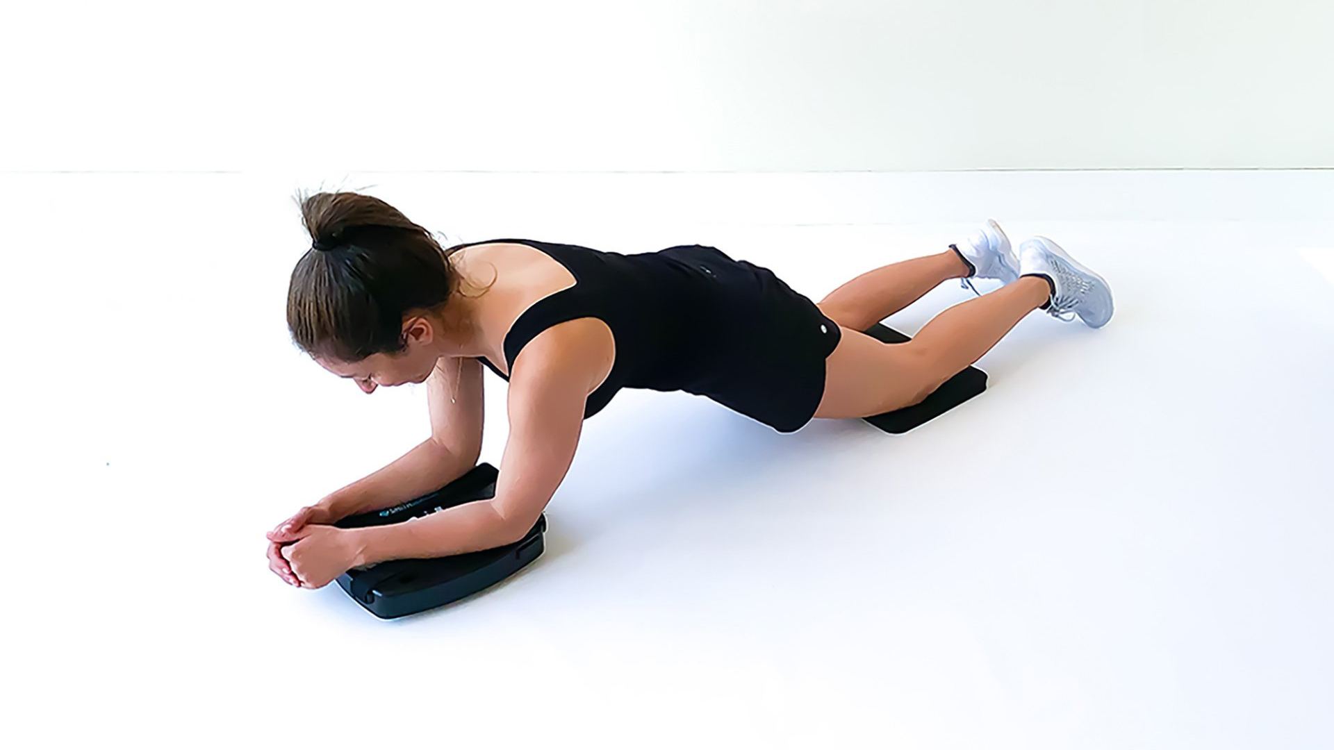 shows a woman performing the SmithShaper Ab Roll exercise on a PRO ASR exerciser with her knees resting on a SmithShaper kneeling pad
