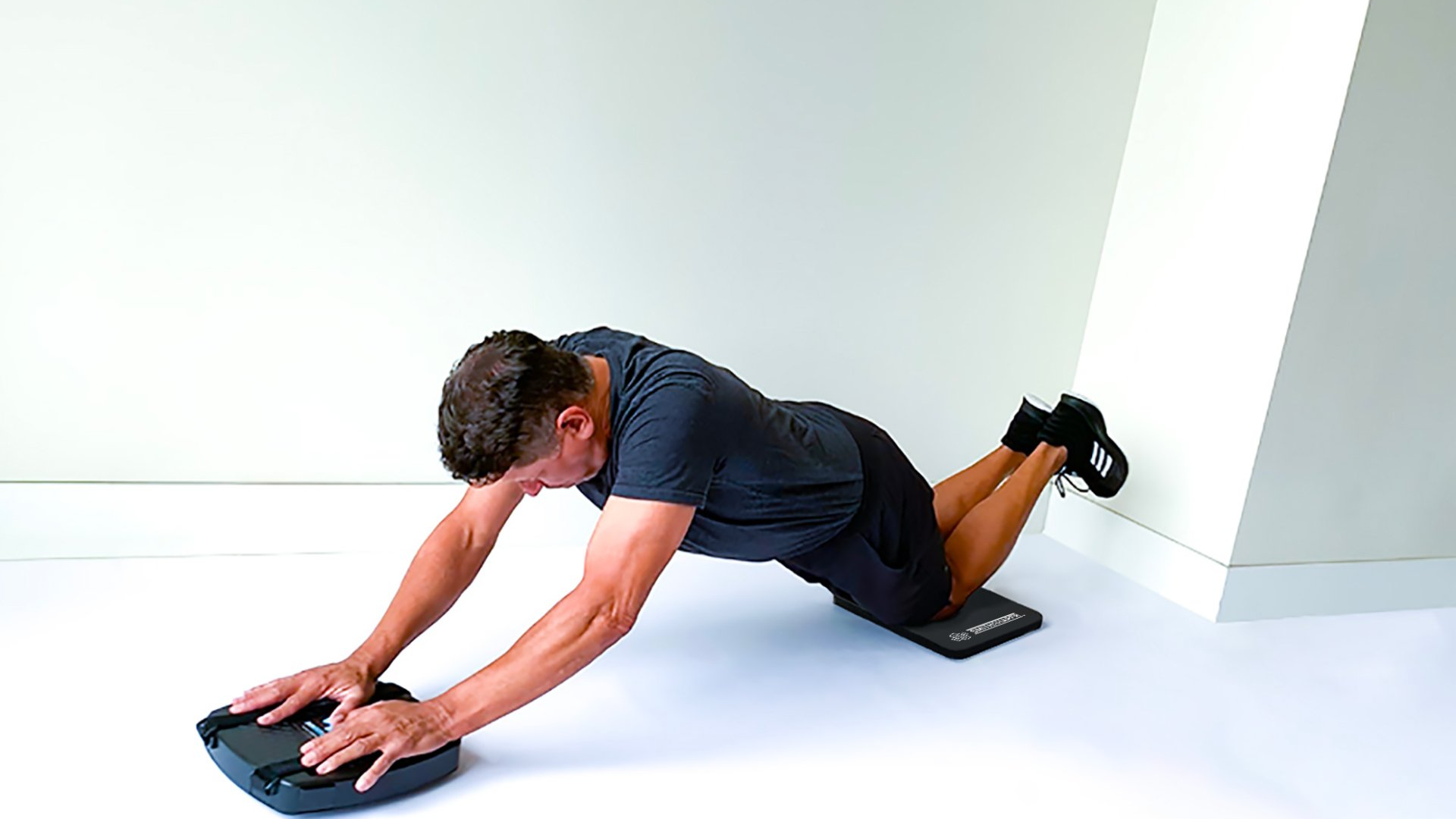 Shows a man performing the ab-roll exercise to strength core and abdominal muscles using the SmithShaper® PRO ASR for Abs, Core, Legs, Butt, Waist, Chest, Arms and Shoulders.
