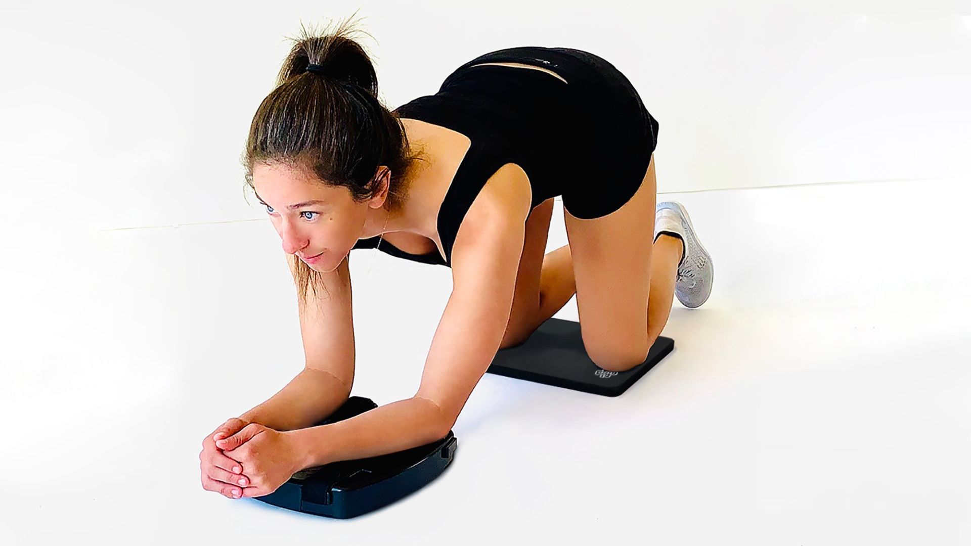 Shows a woman performing at the starting position for the ab-roll exercise - when using forearms - to strength core and abdominal muscles using the SmithShaper® PRO ASR for Abs, Core, Legs, Butt, Waist, Chest, Arms and Shoulders.