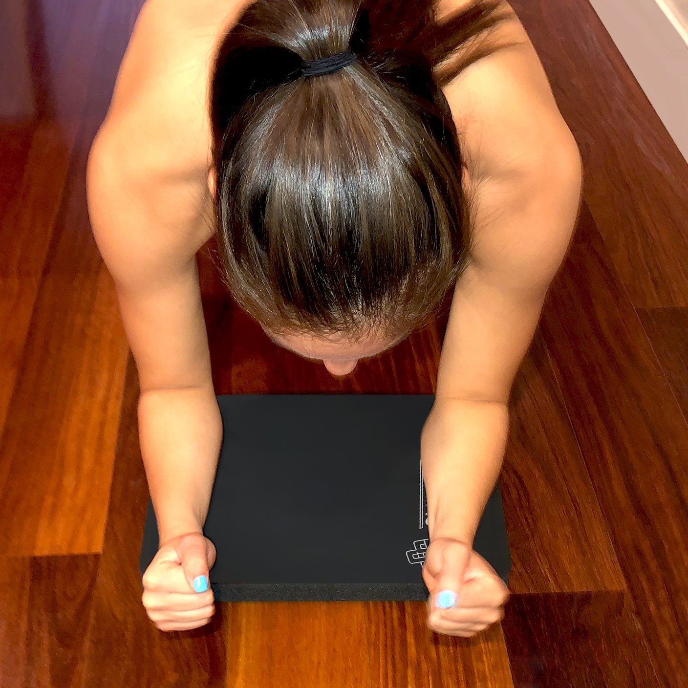 a woman is doing a plank on a black SmithShaper Super Pad Exercise Mat
