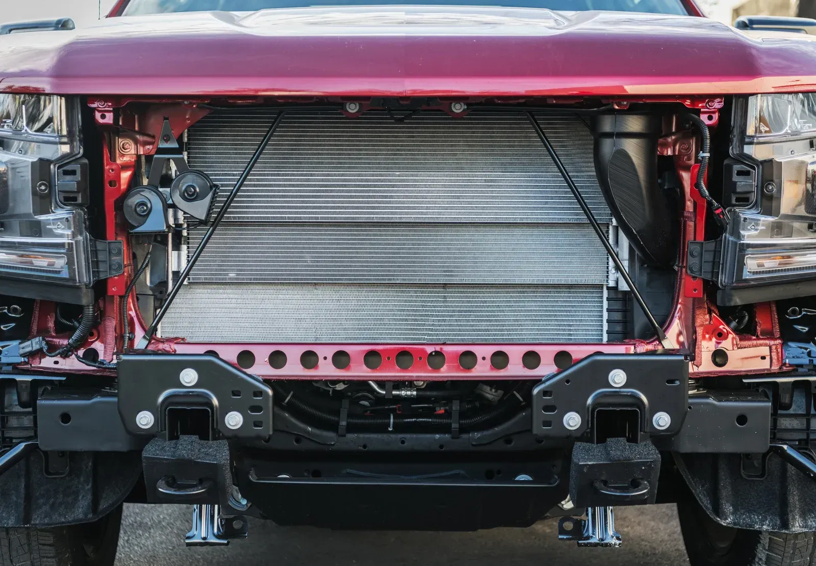 Two-story suburban house with a gray exterior, a two-car garage, and green grass on a wet street at dusk.
