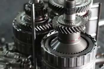 Mechanic working on car brake system, hands on rotor and caliper, garage setting.