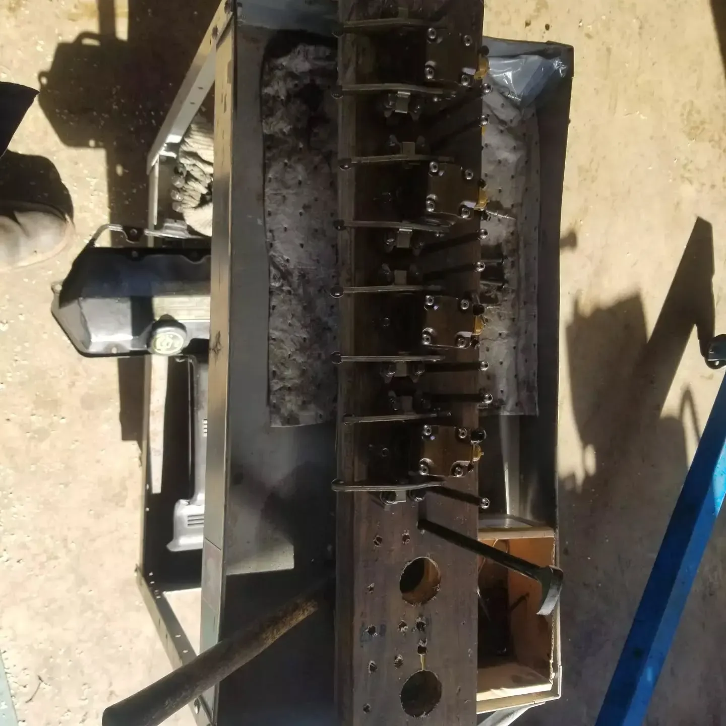 Overhead view of industrial equipment, a metal mold with several compartments and levers.