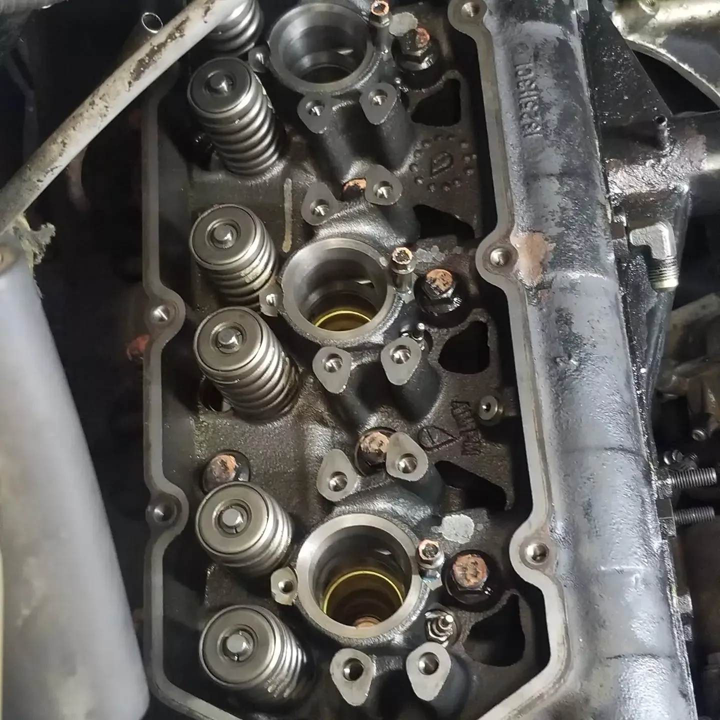 Engine cylinder head with valves and springs visible.