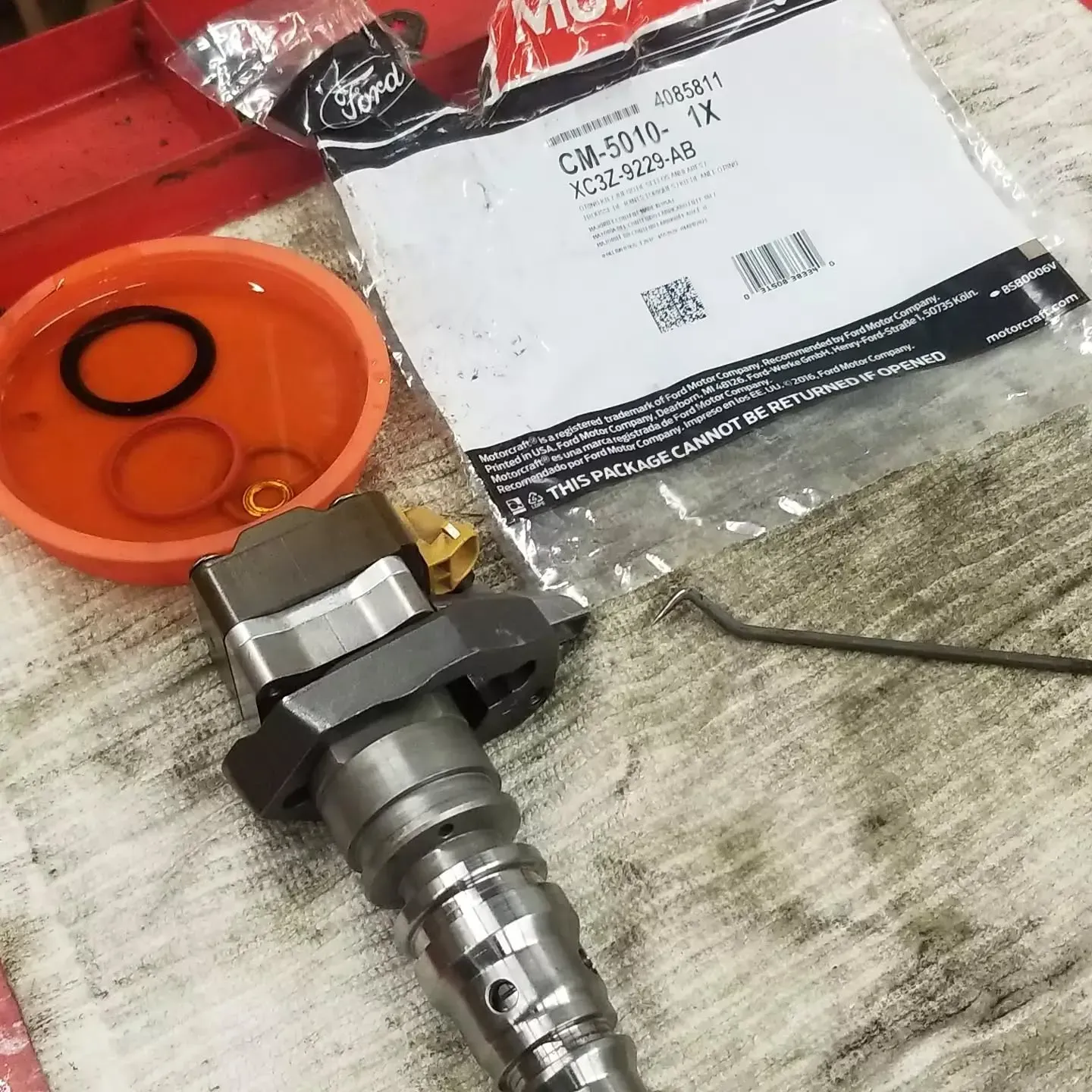 A Ford fuel injector and replacement seals laid out on a shop rag.
