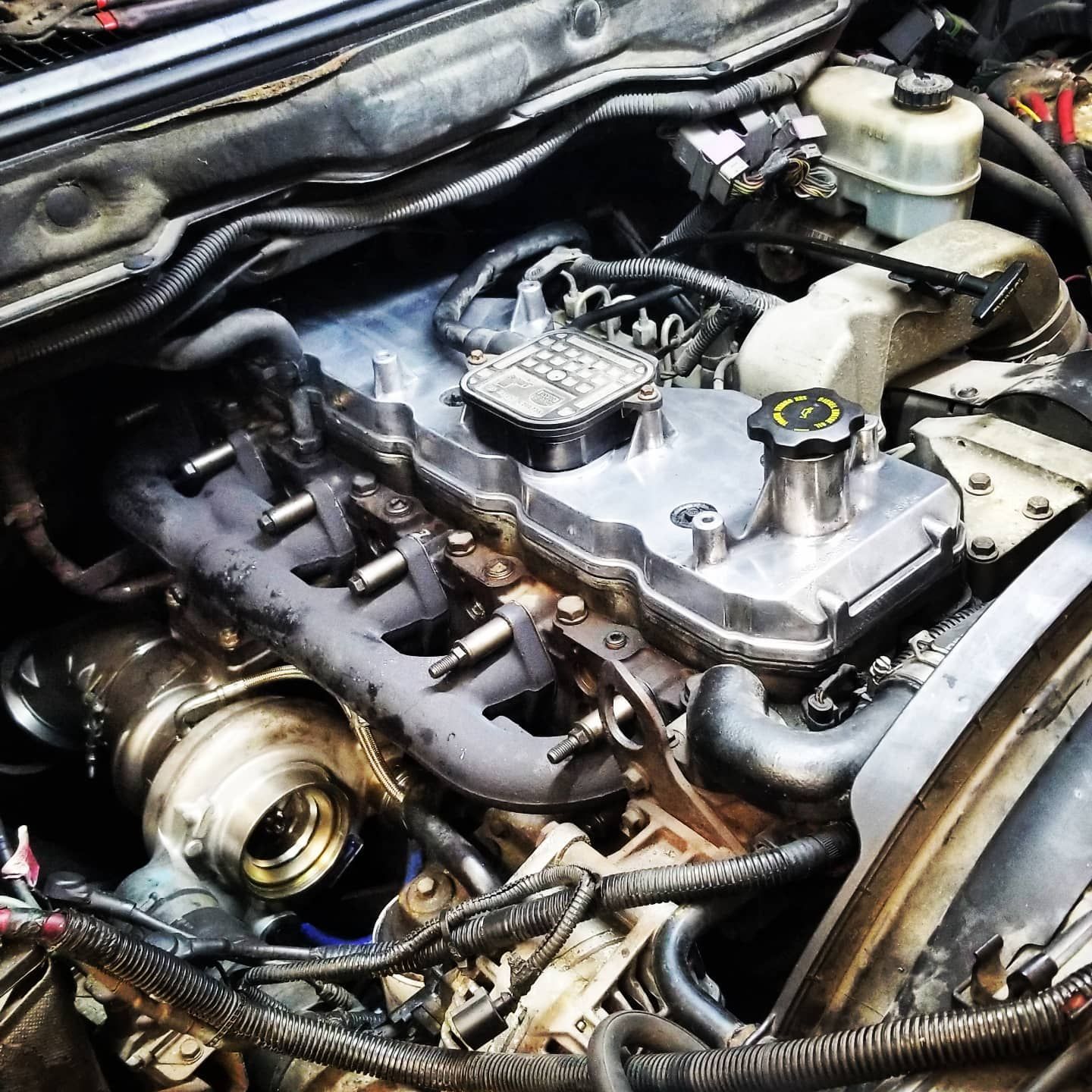 Diesel engine with turbocharger visible, open hood view.