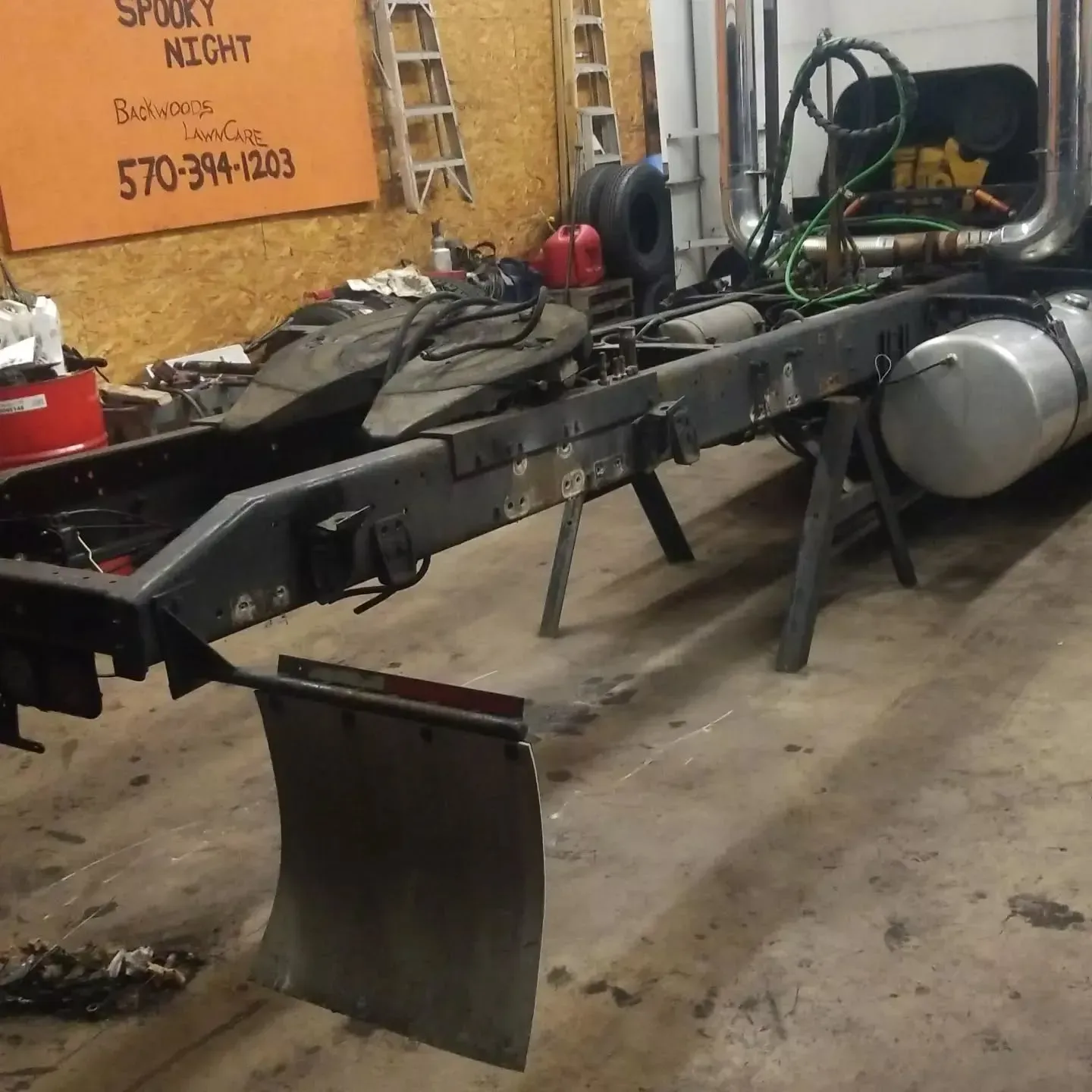 Truck chassis on jack stands in a workshop.