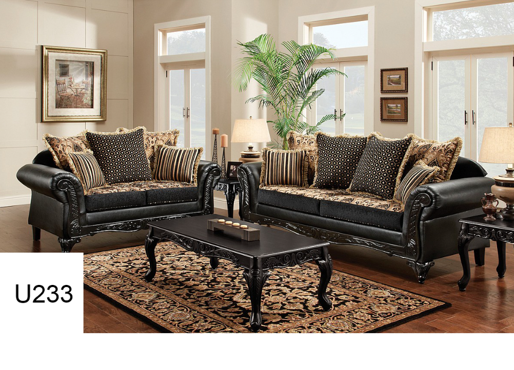 A living room with two black couches and a coffee table