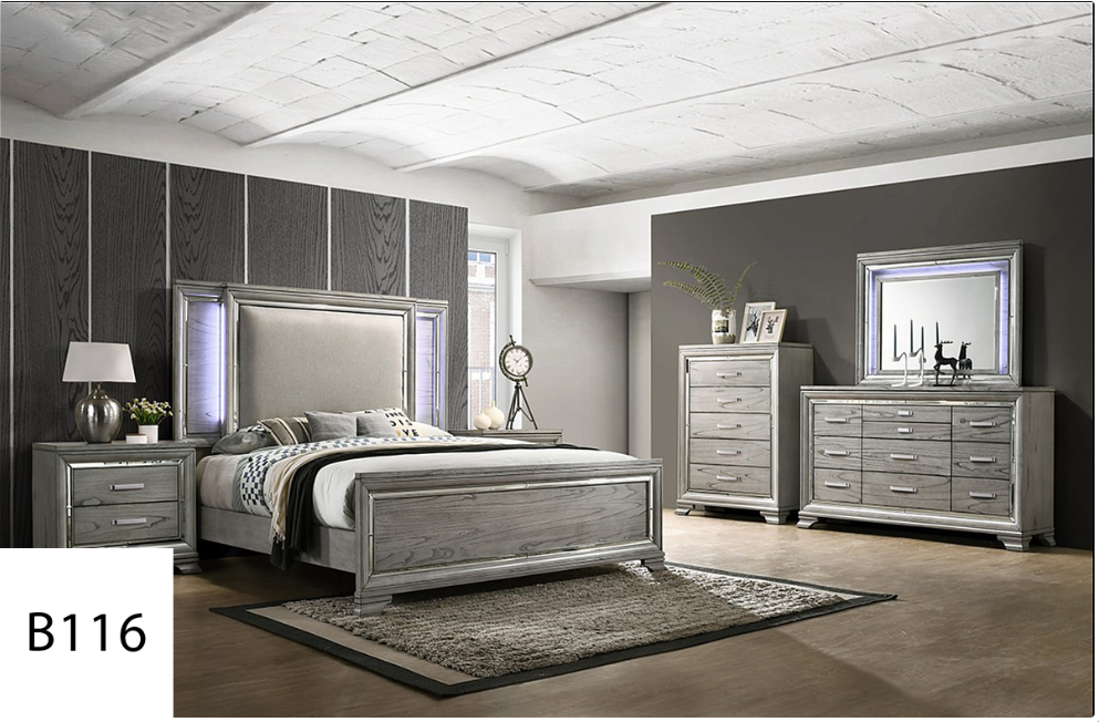 A bedroom with a bed , dresser , nightstand and mirror.
