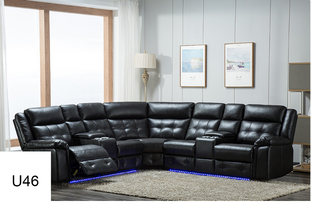 A black leather sectional couch is sitting in a living room next to a window.