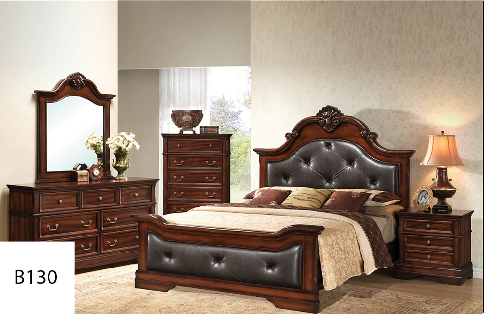 A bedroom with a bed , dresser , nightstand , mirror and lamp.