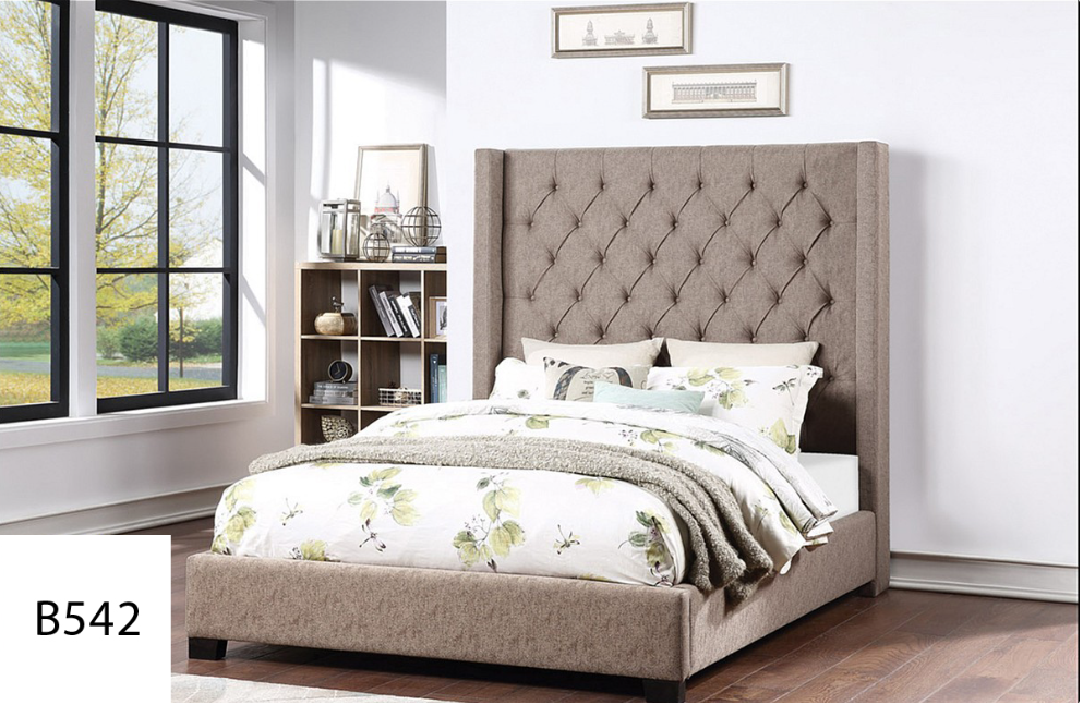 A bed with a tufted headboard is in a bedroom next to a window.