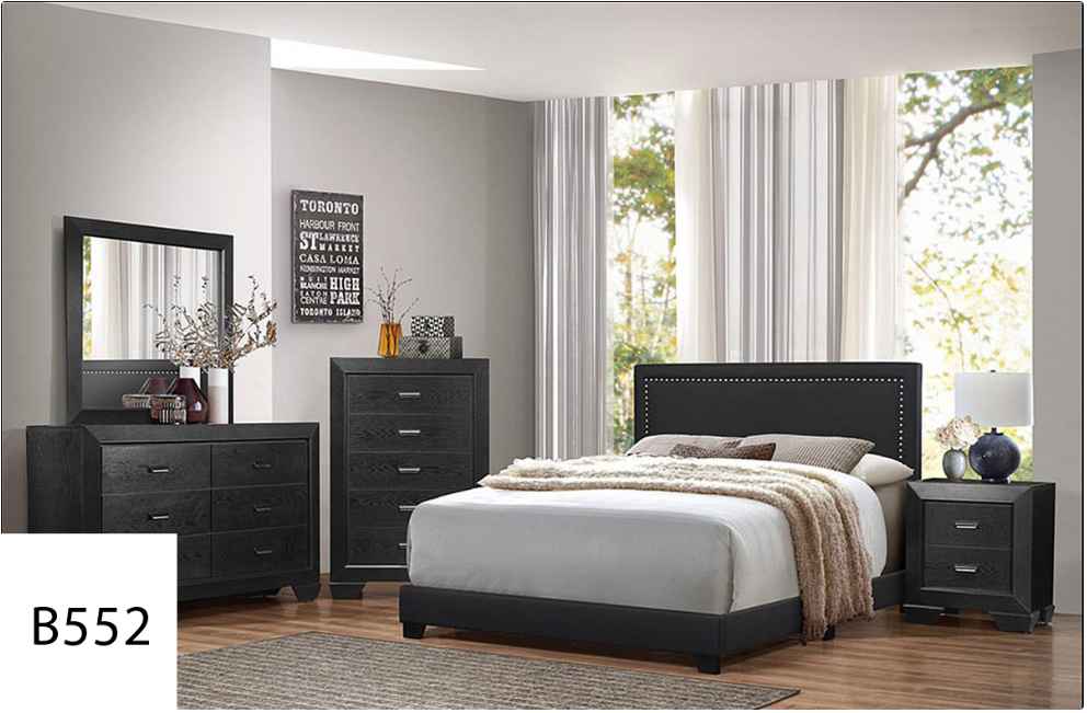 A bedroom with a bed , dresser , nightstand and mirror.