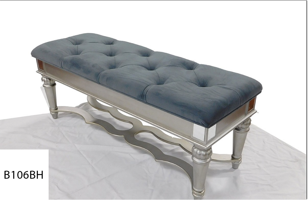 A grey bench with silver legs is sitting on a white surface.