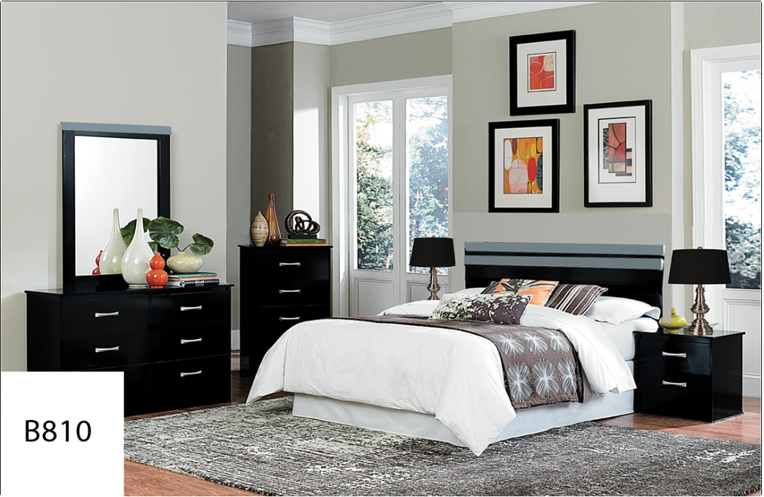 A bedroom with a bed , dresser , nightstand , mirror and rug.
