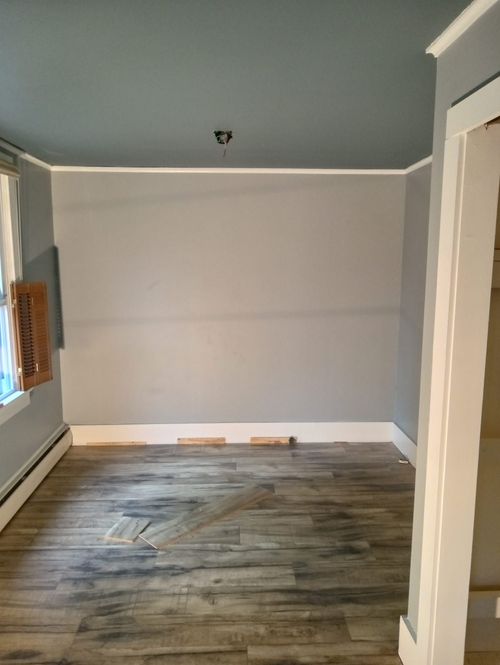 An empty room with a wooden floor and a window.