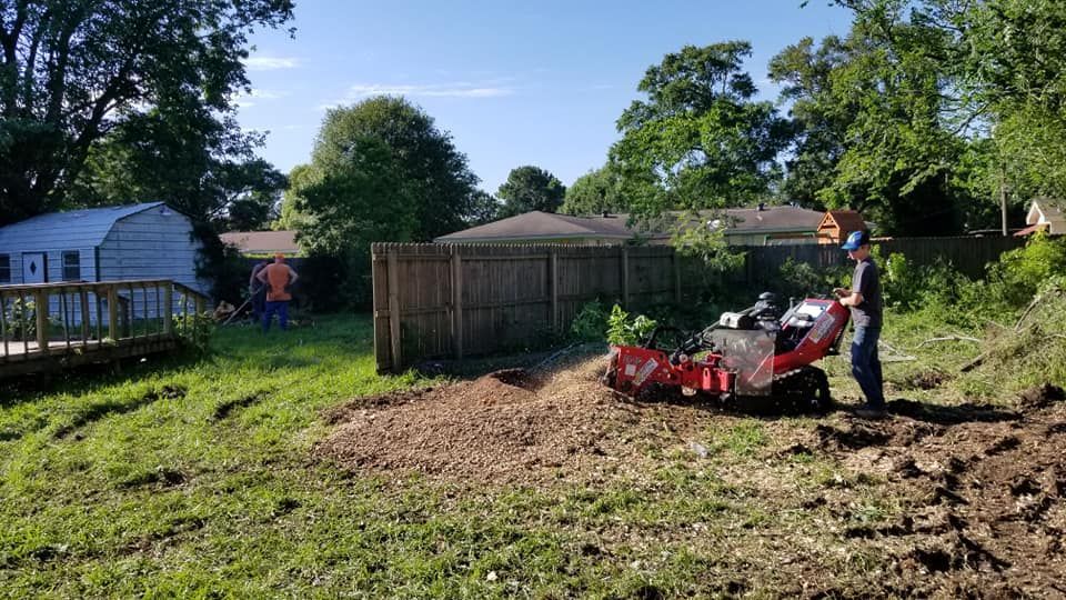 Wood chipper disposing of tree debris into the back of a high sided trailer after a successful tree removal in Beaumont, TX