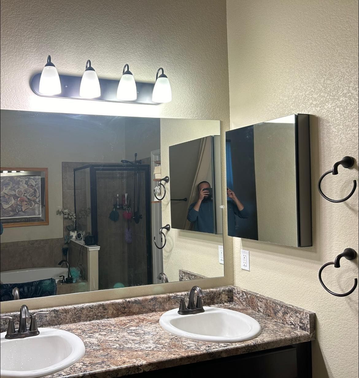 Bathroom with dual sinks, large mirror, medicine cabinet, and overhead lighting.
