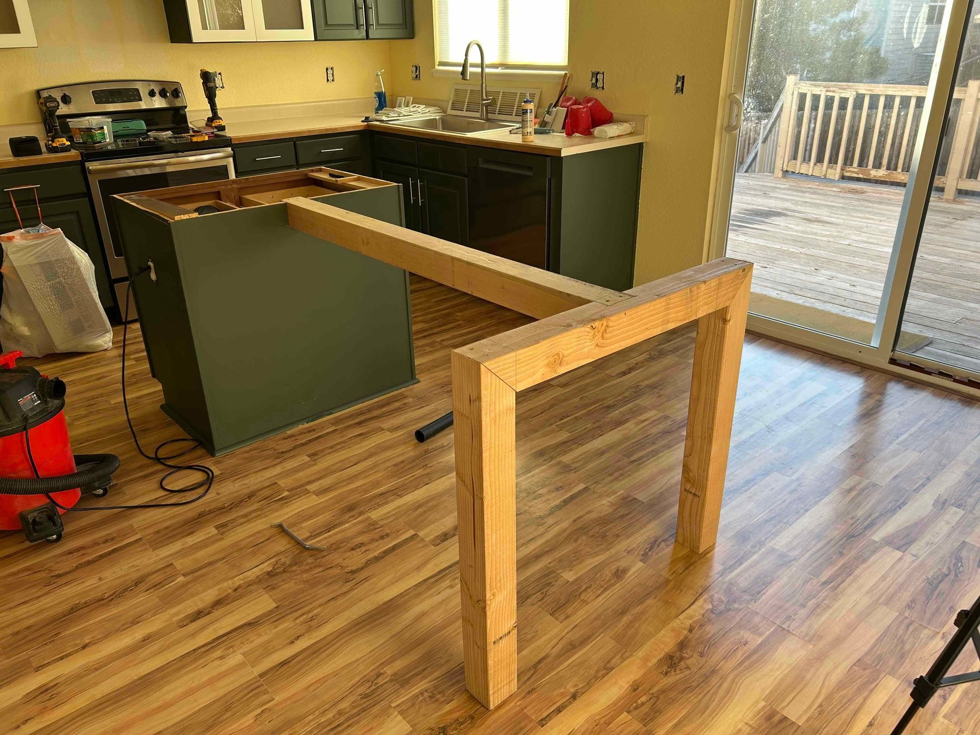 Kitchen island under construction with a wooden frame extending from the cabinets.