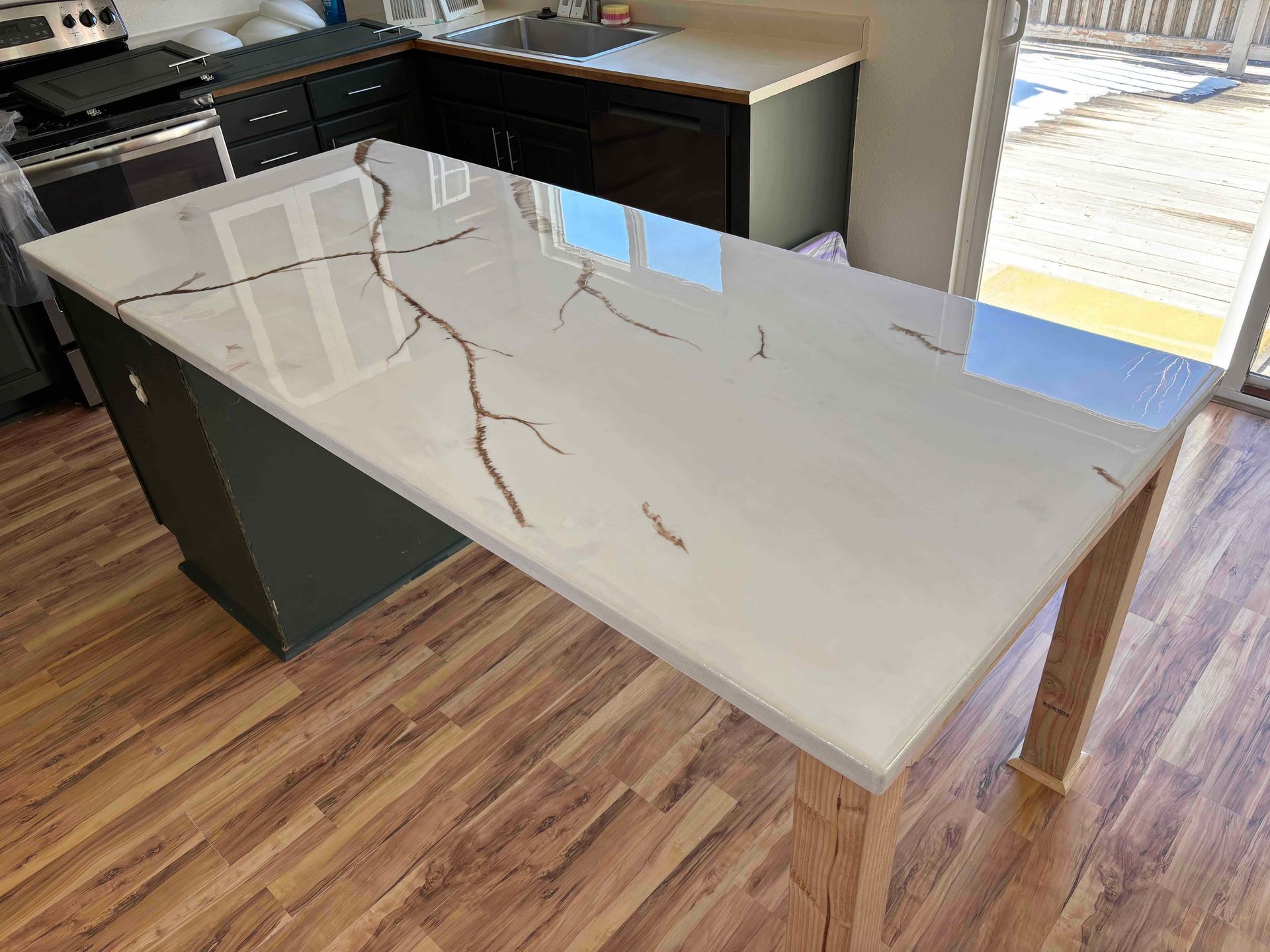 Two-story home with gray siding, a black roof, and a two-car garage, set against a sunset sky.