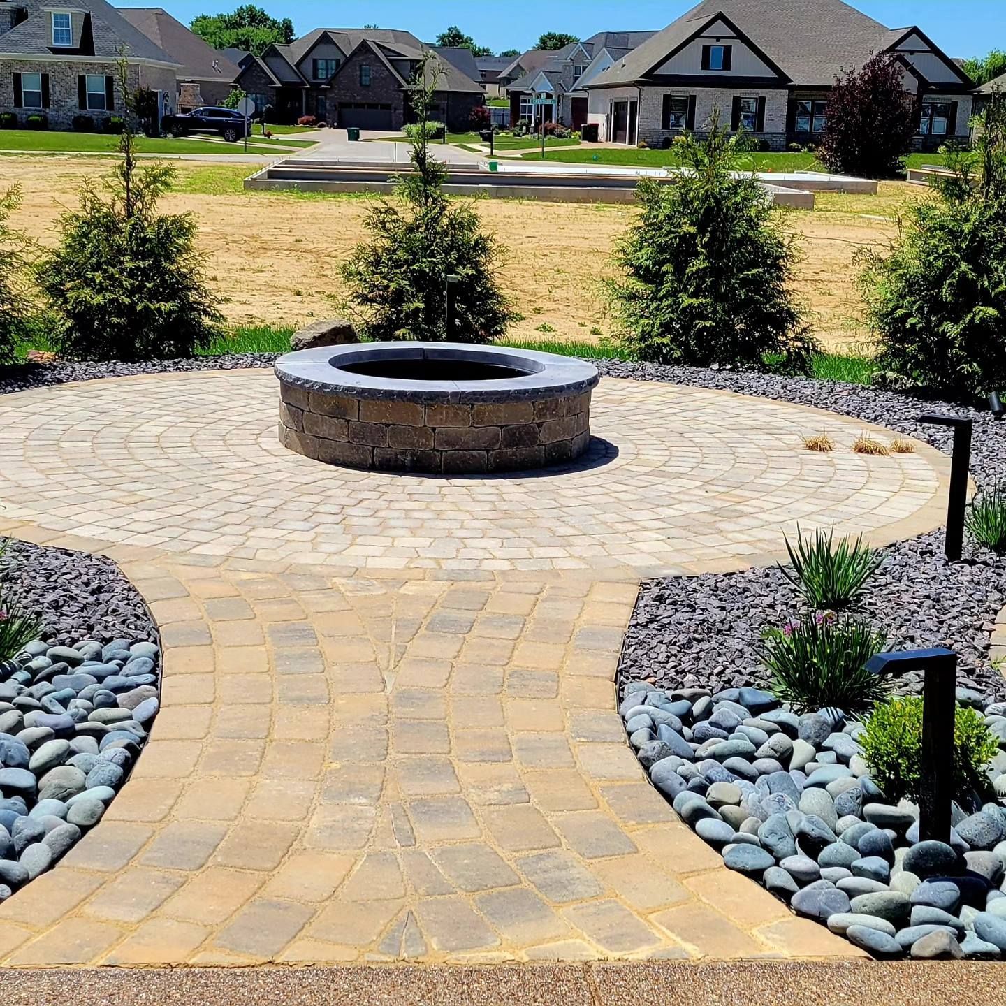 A fire pit in the middle of a brick walkway