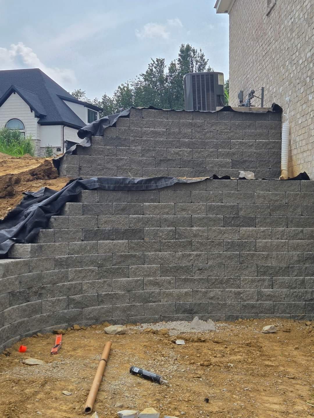 A brick wall is being built in front of a house.