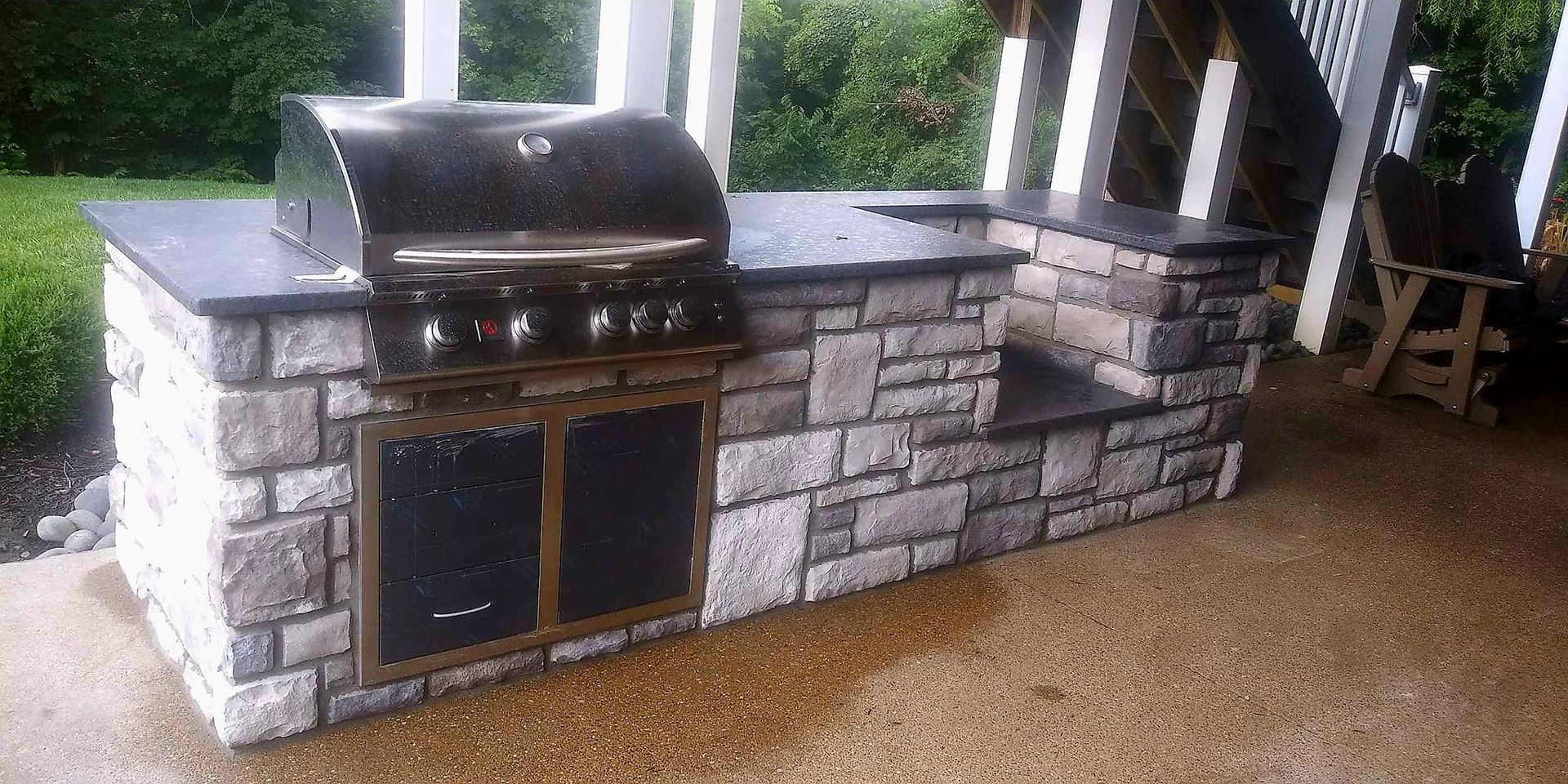 A grill is sitting on top of a stone counter.
