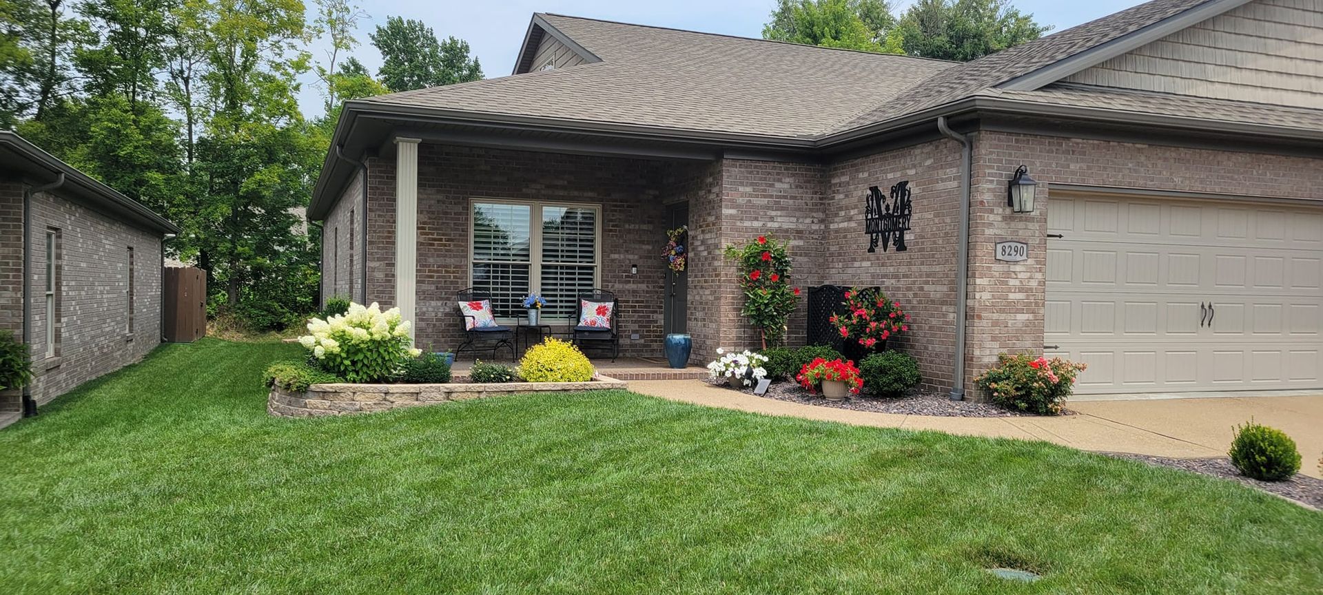 A brick house with a lush green lawn in front of it.