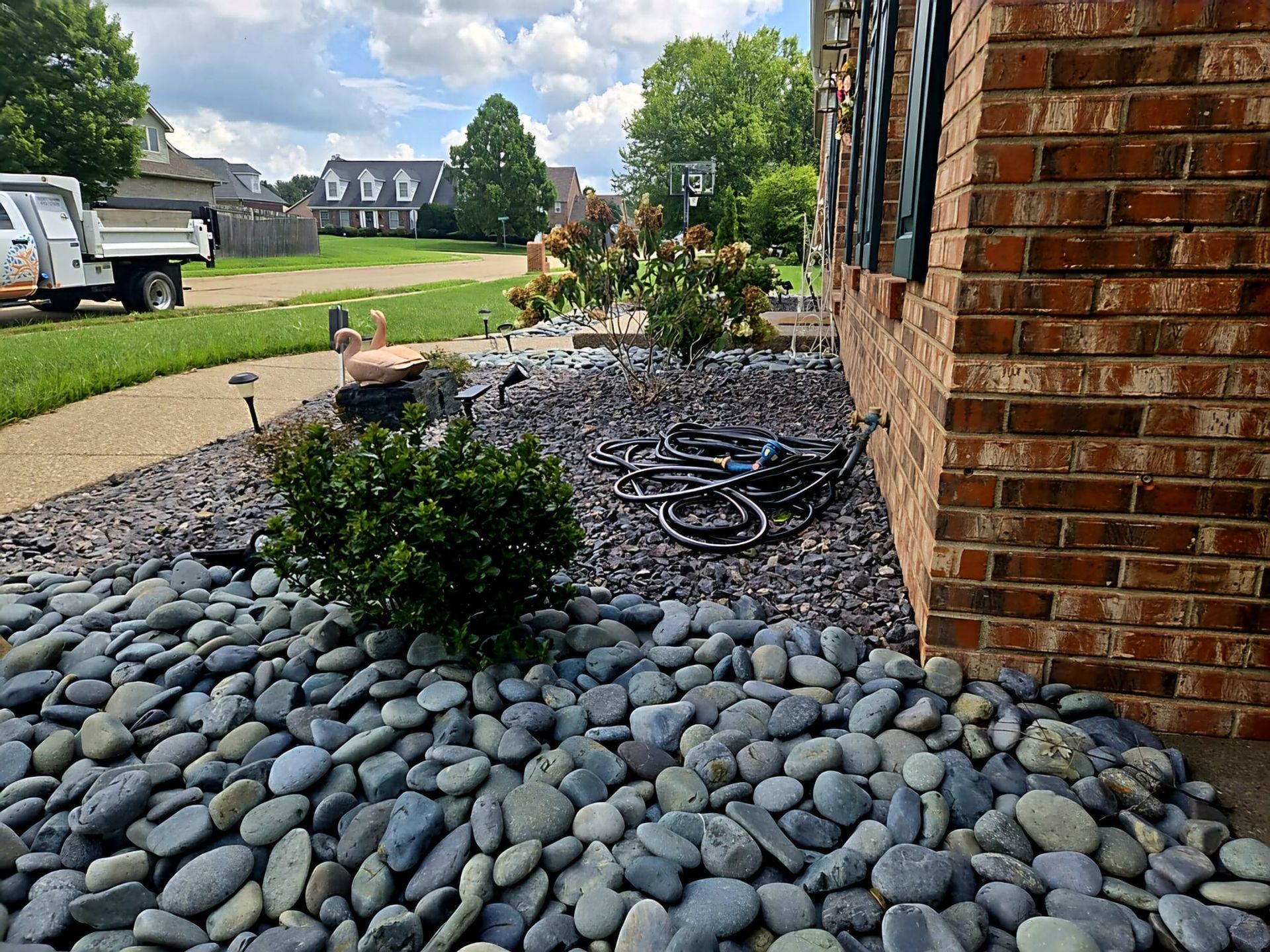 A pile of rocks is in front of a brick building.