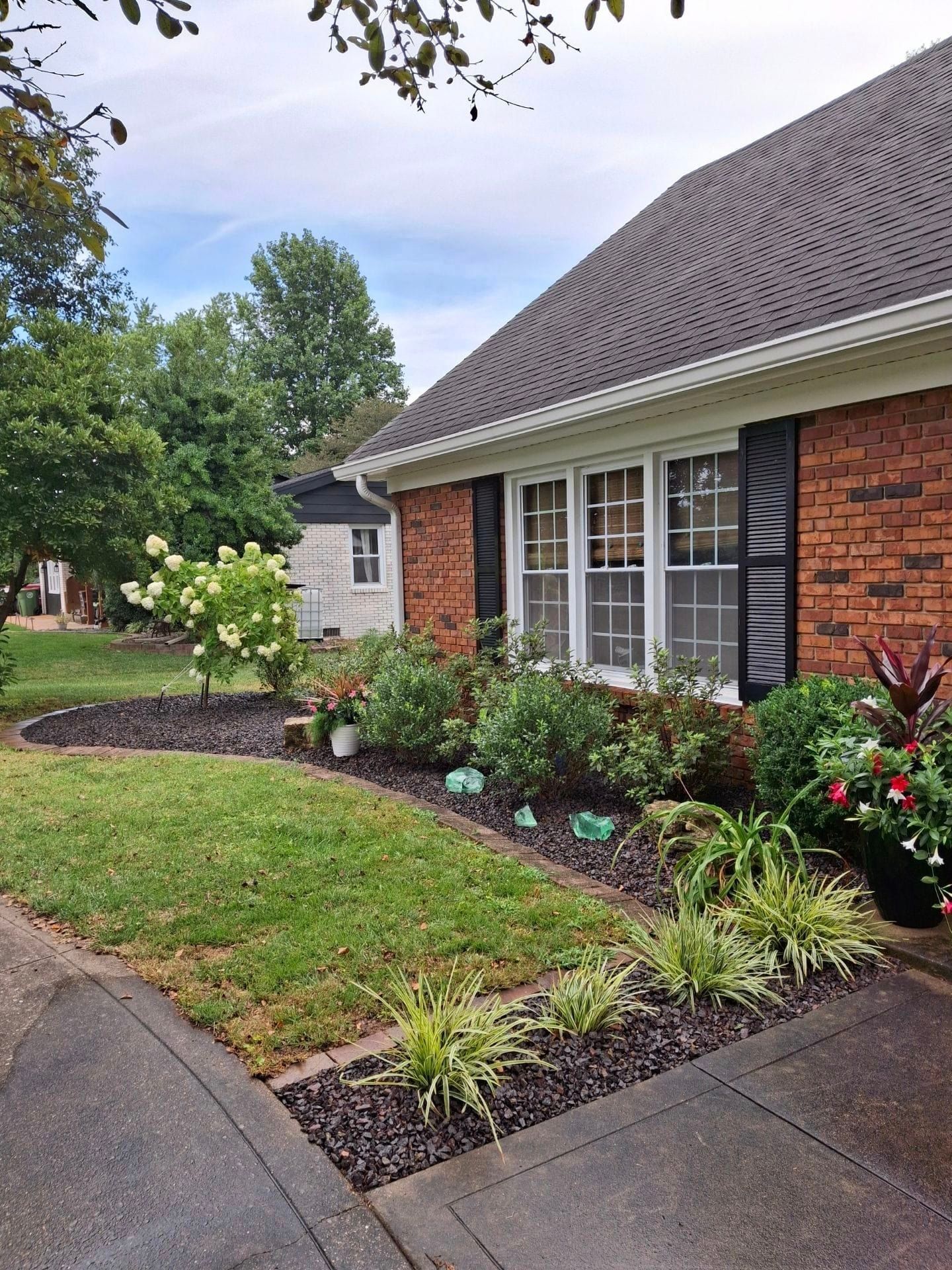 A brick house with a lot of plants in front of it