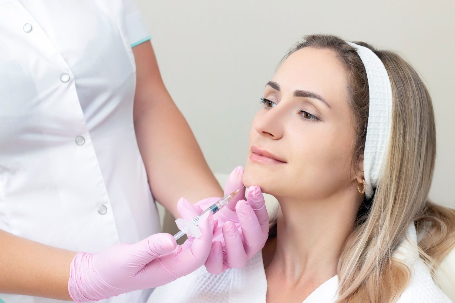 A woman is getting a botox injection in her face.
