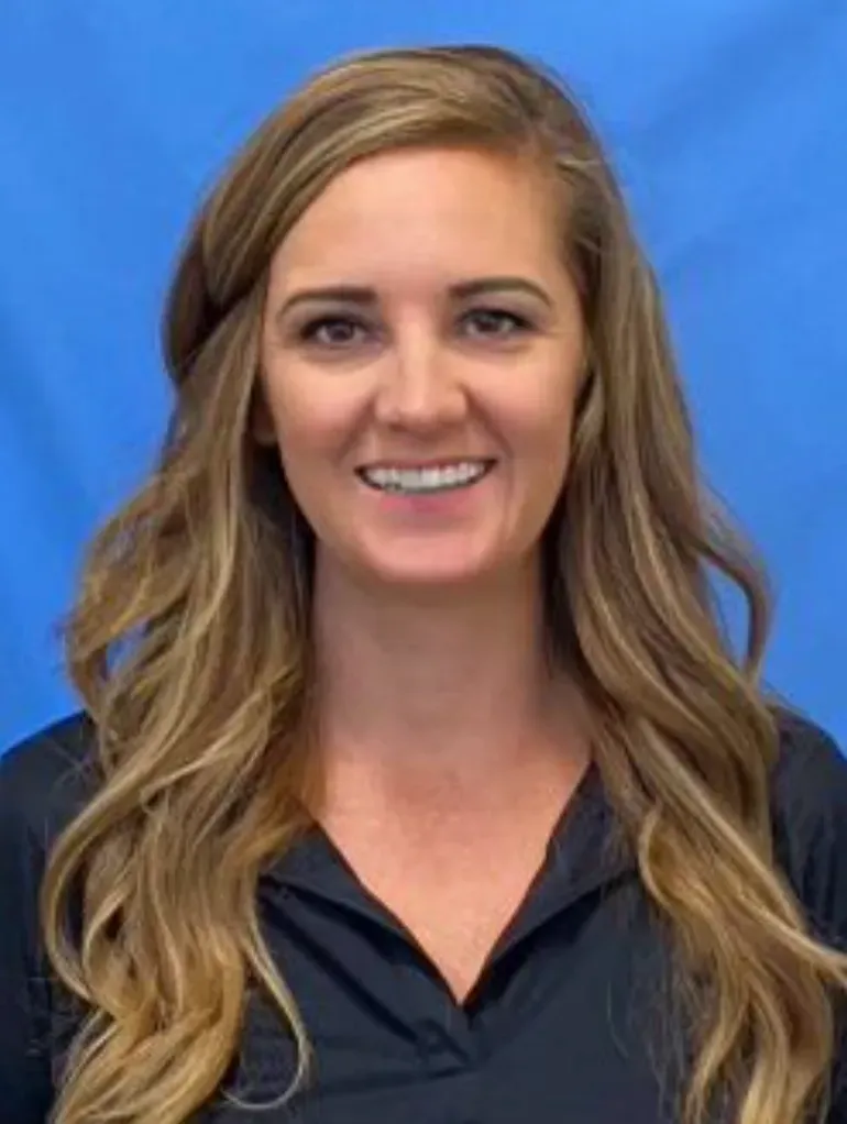 A woman with long blonde hair is smiling and wearing a black shirt.